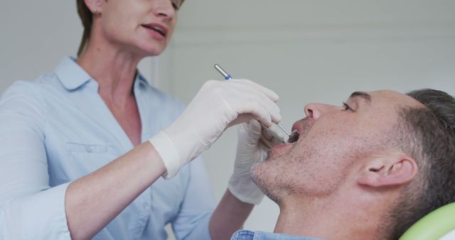 Dentist Examining Male Patient During Checkup Appointment - Download Free Stock Images Pikwizard.com