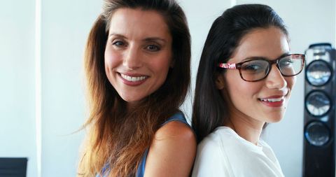 Confident female executives standing back to back