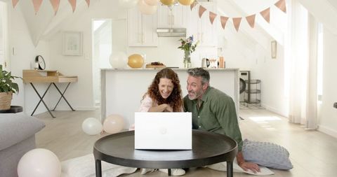 Happy Mature Couple Video Chatting in Sunlit Living Room