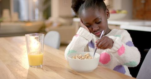Young Girl Enjoying Breakfast with Cereal in Modern Kitchen