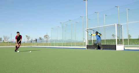 Field hockey players competition at goal on turf field