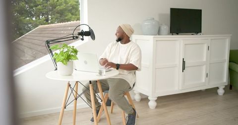 Content creator recording podcast at minimalist home workspace with natural light