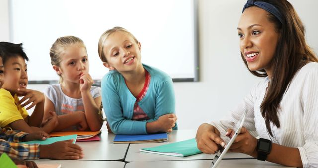 Teacher Engaging with Young Students at Classroom Table - Download Free Stock Images Pikwizard.com