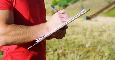 Athletic Trainer Writing on Clipboard at Outdoor Boot Camp - Download Free Stock Images Pikwizard.com