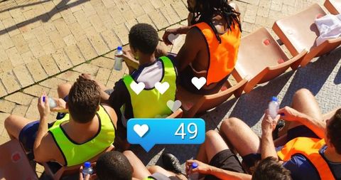 Male Athletes Resting with Social Media Like Overlay at Stadium