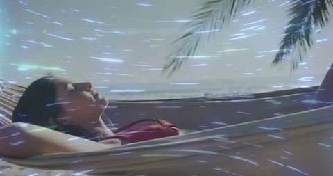 Woman in Hammock Enjoying Ocean Breeze with Tropical Fronds