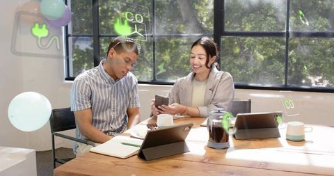 Young professionals collaborating around wooden table with tablets, smartphone and ar icons