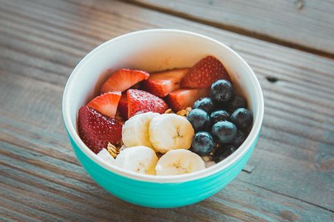 Colorful Breakfast Bowl with Sliced Banana, Fresh Strawberries, Blueberries and Granola