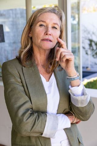Confident Senior Woman Wearing Green Blazer at Home