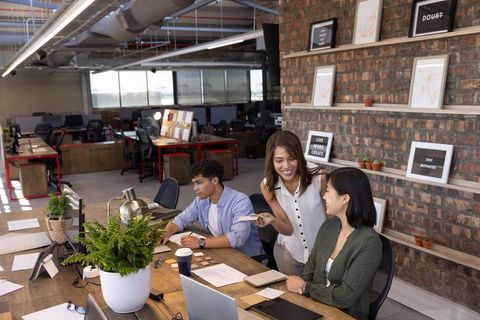 Diverse team collaborating in modern open-plan office workspace