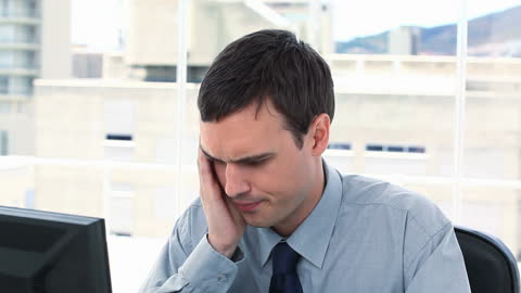Stressed Businessman at Computer in Modern Office Environment