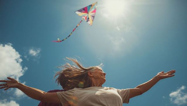 Woman stretching arms toward sun while flying vibrant kite against clear blue sky joyful summer