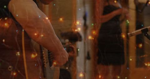 Guitarist Playing Music Amidst Soft Celebratory Lights