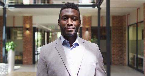 Confident Businessman Smiling in Modern Office Corridor