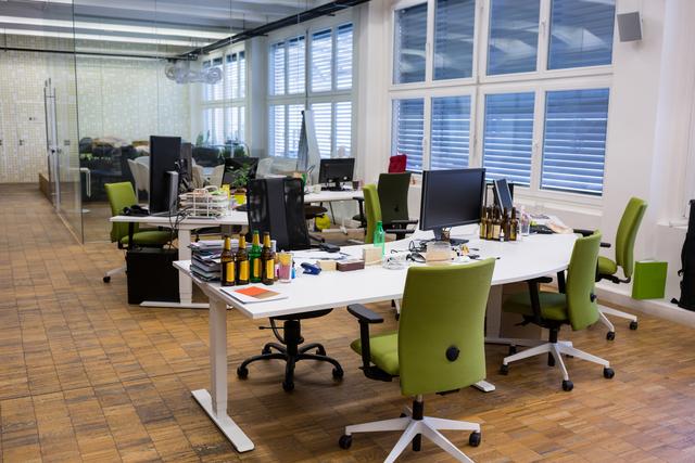 Modern open office space featuring green chairs and white desks, ideal for showcasing contemporary workplace design, corporate environments, and professional settings. Suitable for articles on office organization, business productivity, and modern workspaces.