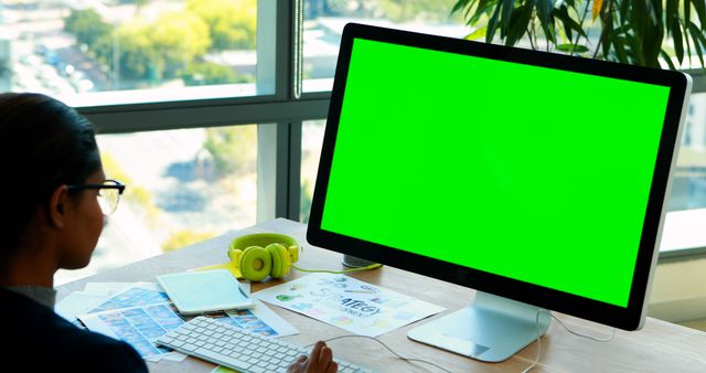 Portrait of biracial businesswoman using computer with green screen working in office, copy space - Download Free Stock Photos Pikwizard.com