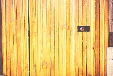 Radiant wooden door with weathered lock in sunlight