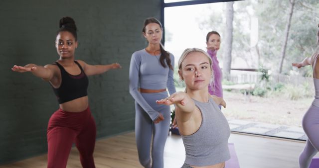 Group of diverse women practicing yoga together in a studio. Ideal for illustrating fitness, wellness, and healthy lifestyle. Can be used for promoting yoga classes, fitness studios, and health-related content.