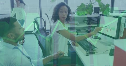 Woman pointing at monitor leading team discussion on data charts and growth trends
