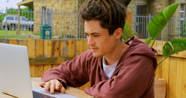 Young Man Working at Outdoor Cafe with Laptop - Download Free Stock Images Pikwizard.com