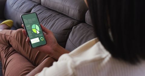 Woman Analyzing Statistics on Smartphone in Living Room