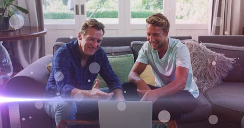 Father and Son Bonding Over Laptop with Digital Light Effects