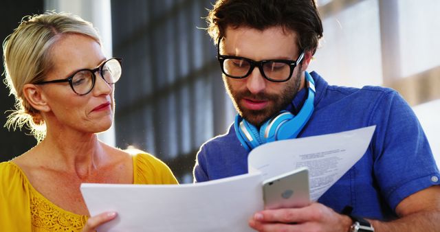 Two Colleagues Analyzing Documents in Office - Download Free Stock Images Pikwizard.com