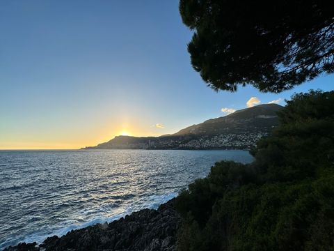 Stunning beach sunrise over rocky shores and rolling hills