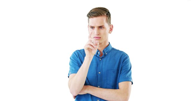 Young man is shown with a thoughtful expression, holding his finger. Wears blue casual shirt, has arms crossed. Useful for illustrating concepts related to thinking, problem solving, decision making, or planning. Appropriate for articles or advertisements related to personal development, mental processes, or professional contemplation.