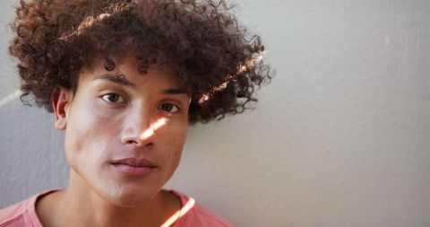 Young Man with Curly Hair Displaying Confidence