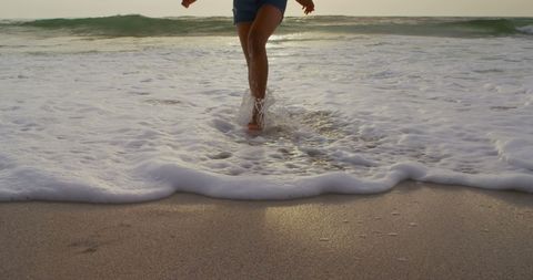 Woman Running on Sunlit Beach with Ocean Waves - Download Free Stock Images Pikwizard.com