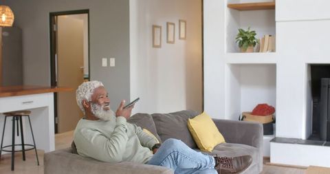 Senior Man Communicating on Smartphone in Comfortable Living Room
