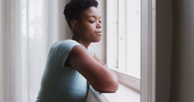 Thoughtful African-American Woman Looking Out Window in Natural Light - Download Free Stock Images Pikwizard.com