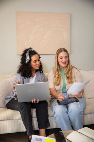 Diverse Coworkers Collaborating with Technology on Sofa
