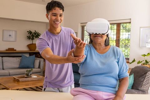 Senior Woman Experiencing Virtual Reality with Grandson at Home