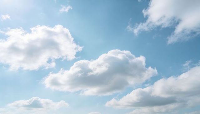Floating cumulus cloudscape over bright blue sky with soft sunlight and airy minimal mood