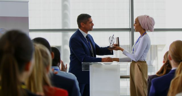 Side view of a Caucasian businessman receiving an award from a businesswoman while the public is applauding him in the business seminar 4k