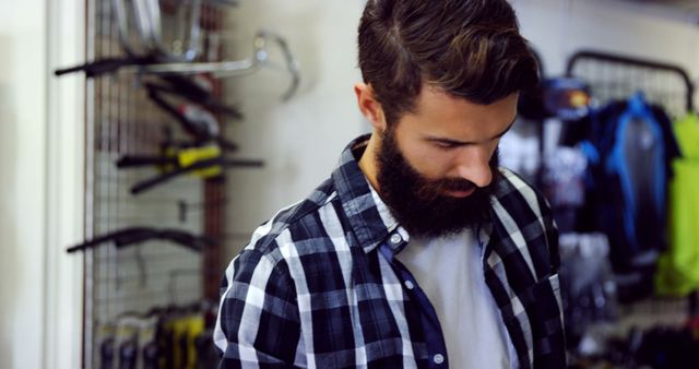 Man with Beard Wearing Checkered Shirt in Bicycle Shop - Download Free Stock Images Pikwizard.com