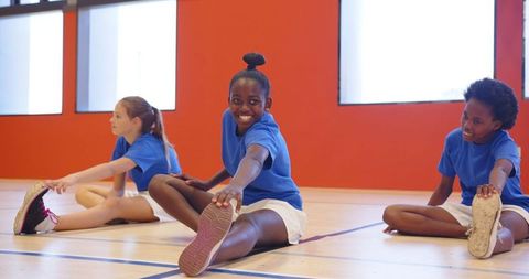 Diverse Kids Stretching for Fitness in Gym Class