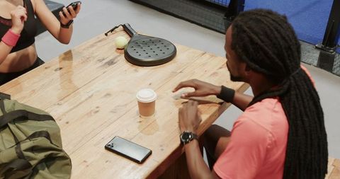 Padel Players Relaxing with Smartphone and Coffee
