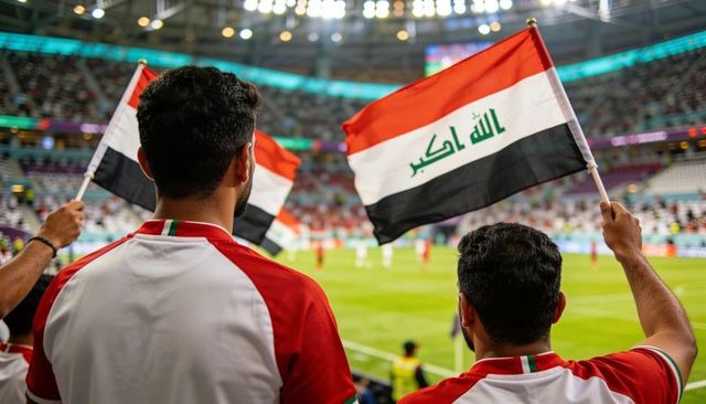 Iraqi football fans cheering and waving flags in packed stadium under floodlights
