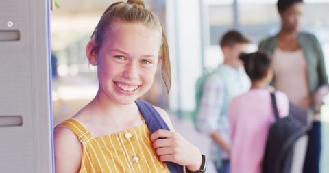 Smiling Schoolgirl Holding Backpack in Vibrant School Environment - Download Free Stock Images Pikwizard.com