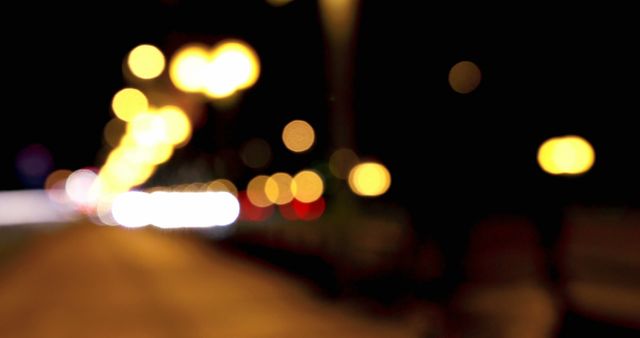 This photo depicts a city road at night with defocused traffic and street lights, suggesting a lively urban nightlife. It includes a bokeh effect from the blurred lights. This photo can be used in contexts related to city life, nightlife, urban exploration, and travel. It captures the vibrant energy of the city after dark, useful for demonstrating movement, evening activities, and the ambiance of night settings in various editorial and creative projects.