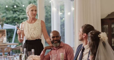 Elderly woman giving speech at wedding reception