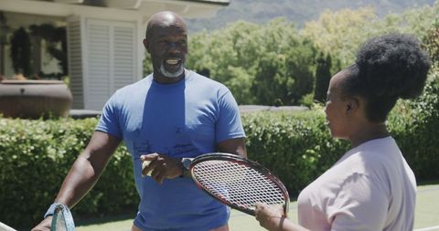 Active Senior Couple Enjoying Tennis Outdoors on Sunny Day