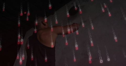 Silhouette man reaching for wall device with falling binary code overlay industrial tech