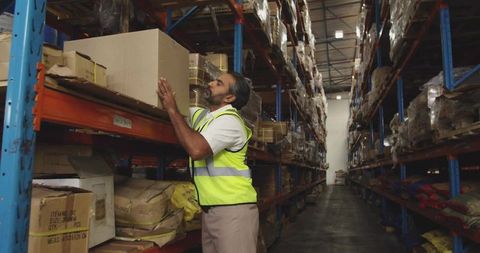 Warehouse Worker in High Visibility Vest Organizing Boxes