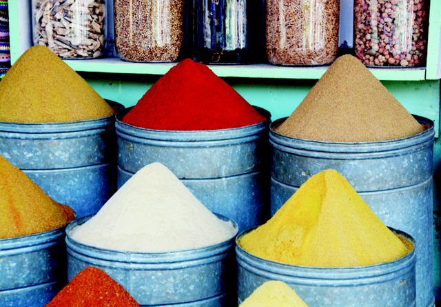 Visually appealing display of various colorful spices piled in market containers. Ideal for use in articles, blogs, or recipes that discuss food, cooking, and culinary diversity. Can also suit educational materials detailing different spices and their uses.