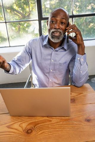 Confident Professional Senior Man on Phone Working at Modern Office Desk