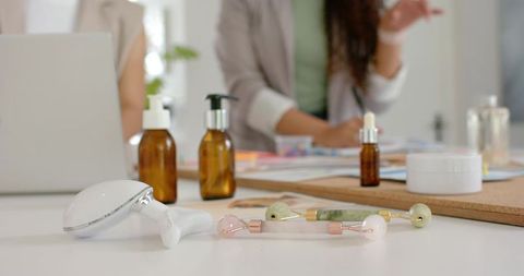 African american women reviewing skincare products with jade and rose quartz rollers